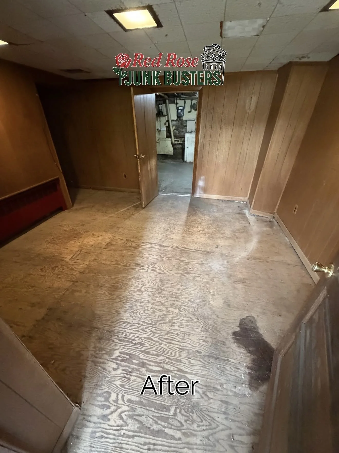 Room with wooden walls and flooring, partially cleaned with a washing effect, and an open door leading to a utility space.