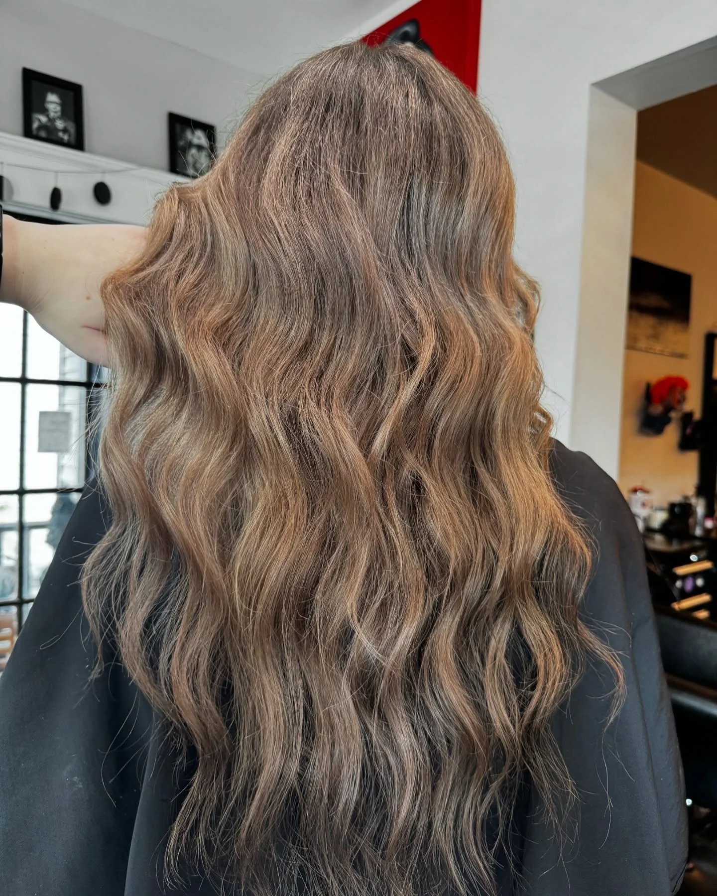 Wavy, light brown hair on a person in a salon.