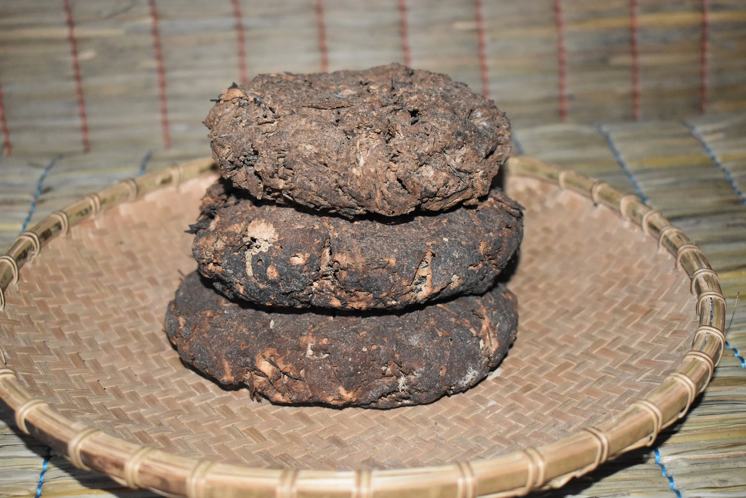 Dried Atheeh which are remnants of fermented fern after rubbing it to extract the desired Atheeh. These remnants are shaped into balls or rotis then placed on the Tajwe (a raised platform over the fire, found in every village house, used for drying v