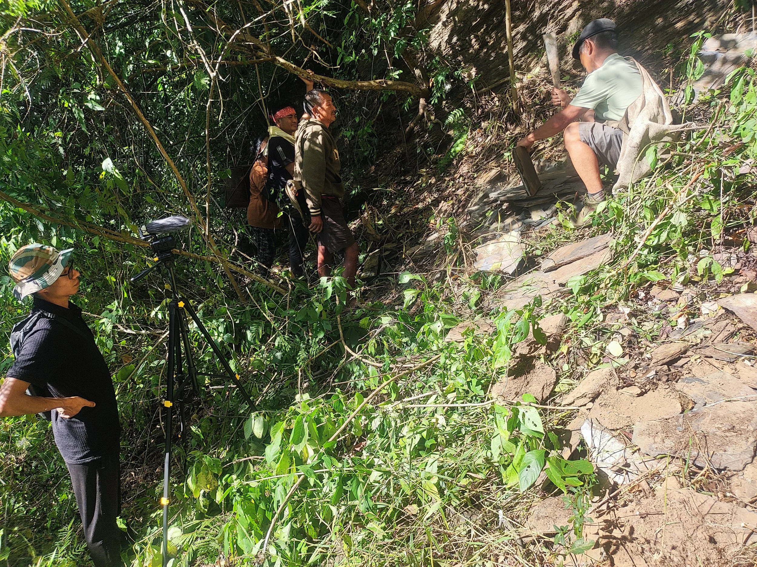 Peyam (L) filming the crew as they extract slate from the site known as Lungpaikhan.
