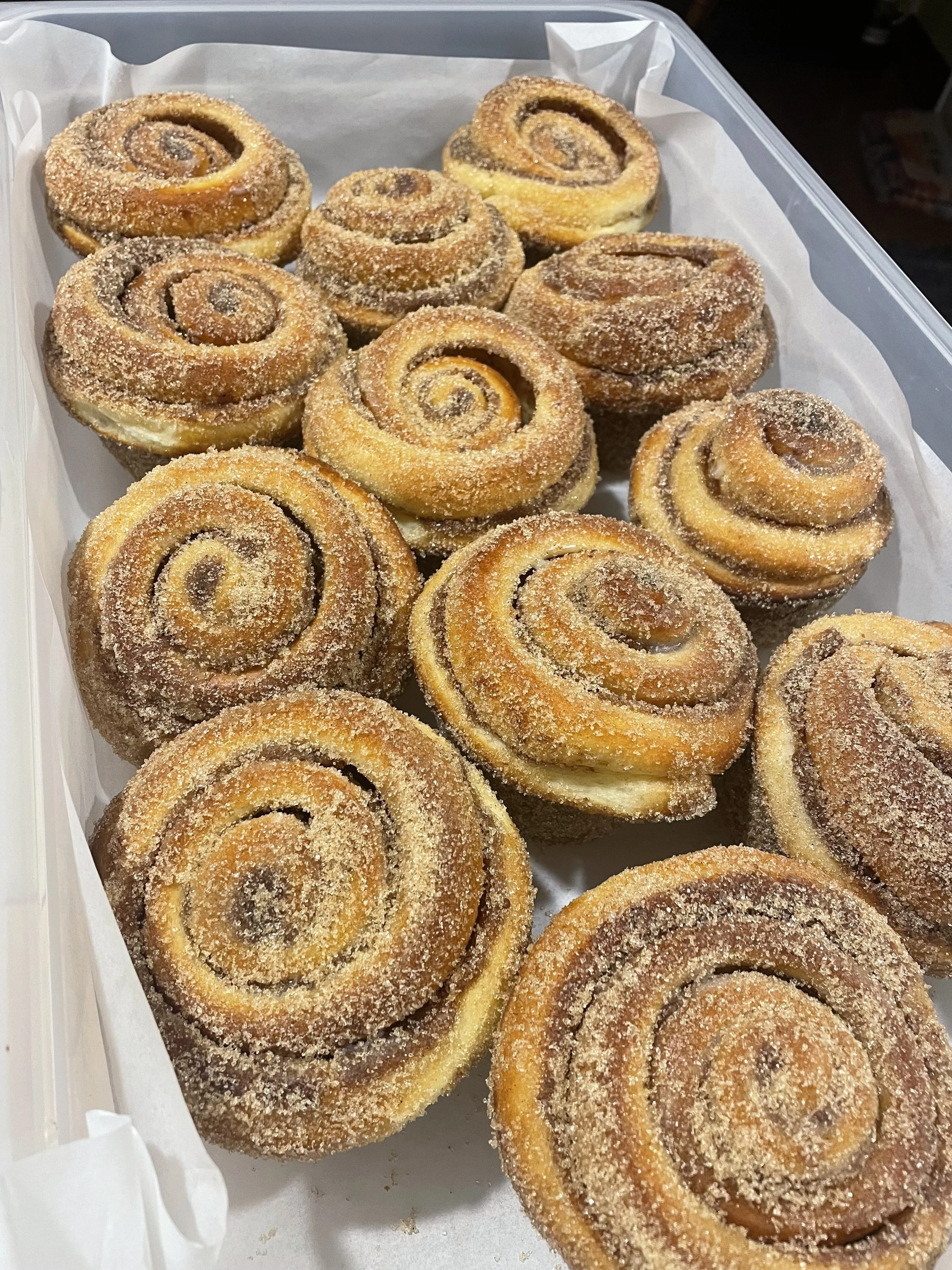A tray of cinnamon rolls with sugar and cinnamon topping.