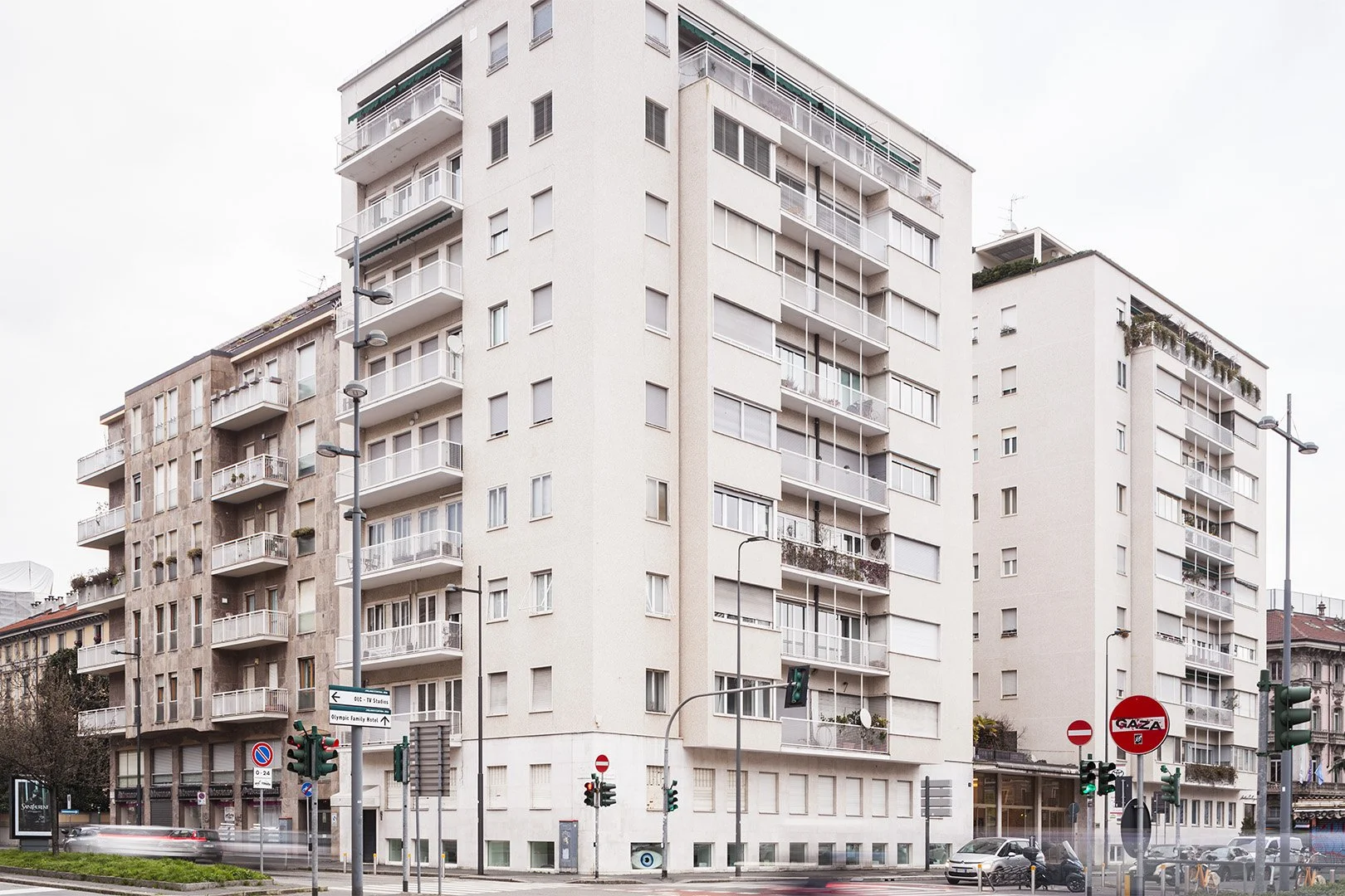 Edificio residenziale a più piani in città, con balconi e un traffico di auto e moto sulla strada