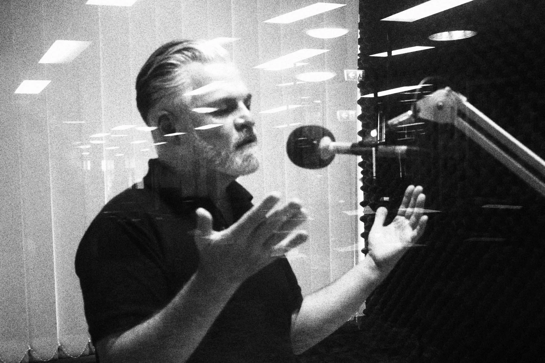 Client speaking expressively into a studio microphone during a Your Voice Coaching recording session in a professional voice studio.