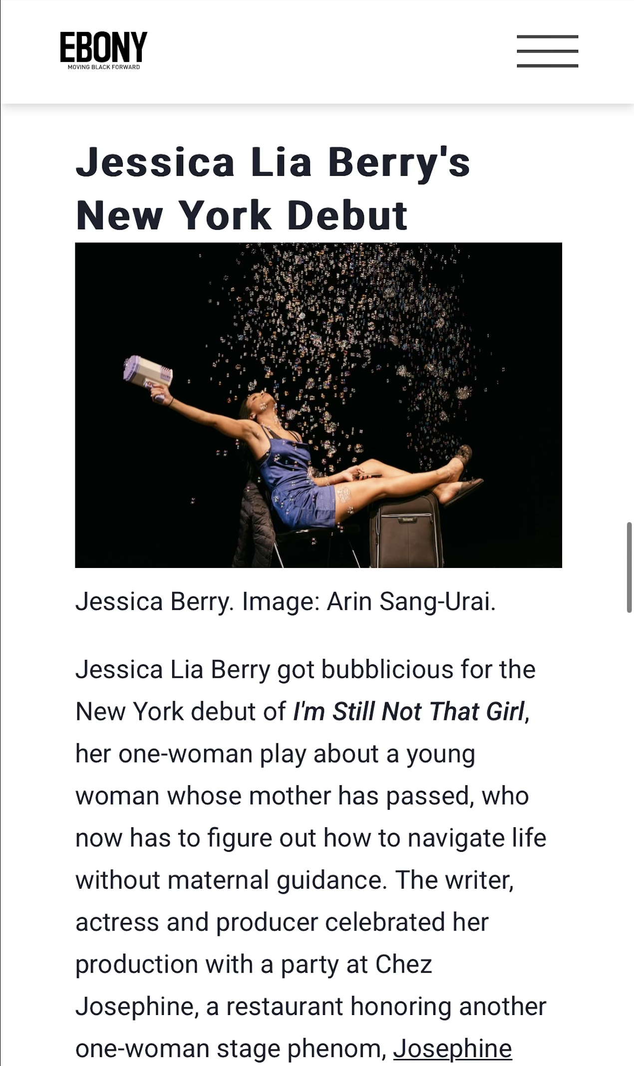 An article headline announcing Jessica Lia Berry's New York debut with an accompanying photograph of her seated on a chair, wearing a blue dress and boots, with champagne being poured over her head for celebration.