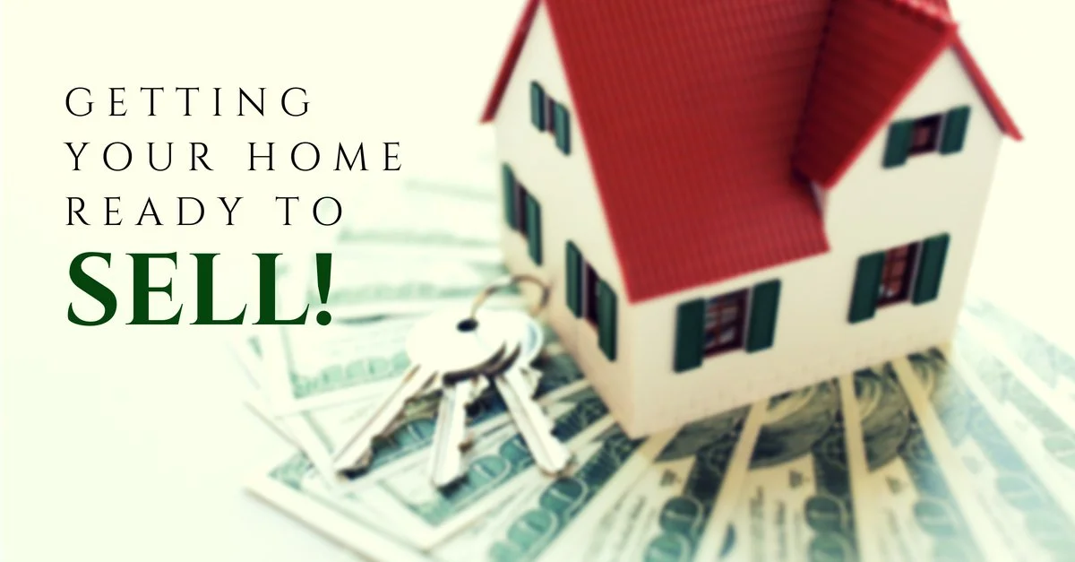 A small model house with a red roof sitting on top of scattered dollar bills and a set of keys next to it, with text reading "Getting your home ready to sell!"