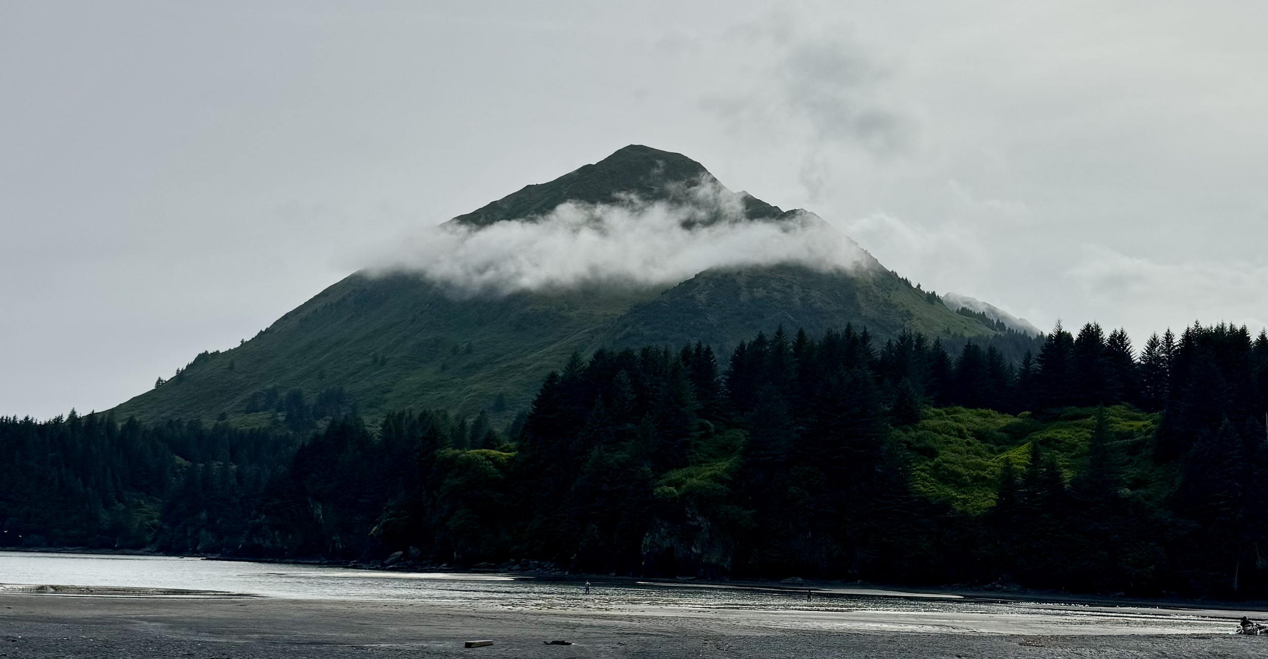 Mountain with clouds in the middle and water at the bottom