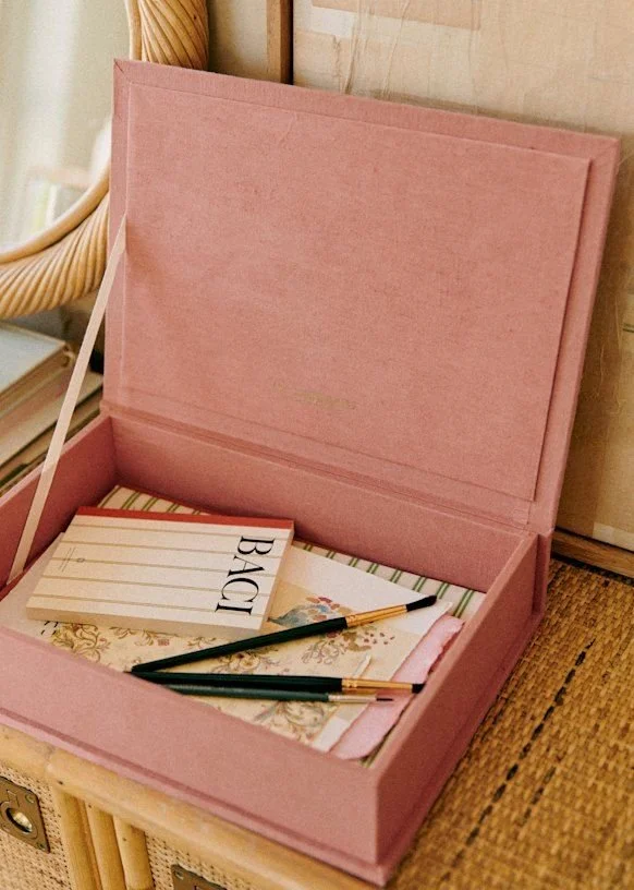 Pink box opened on showing papers stored inside used for a small table storage box.
