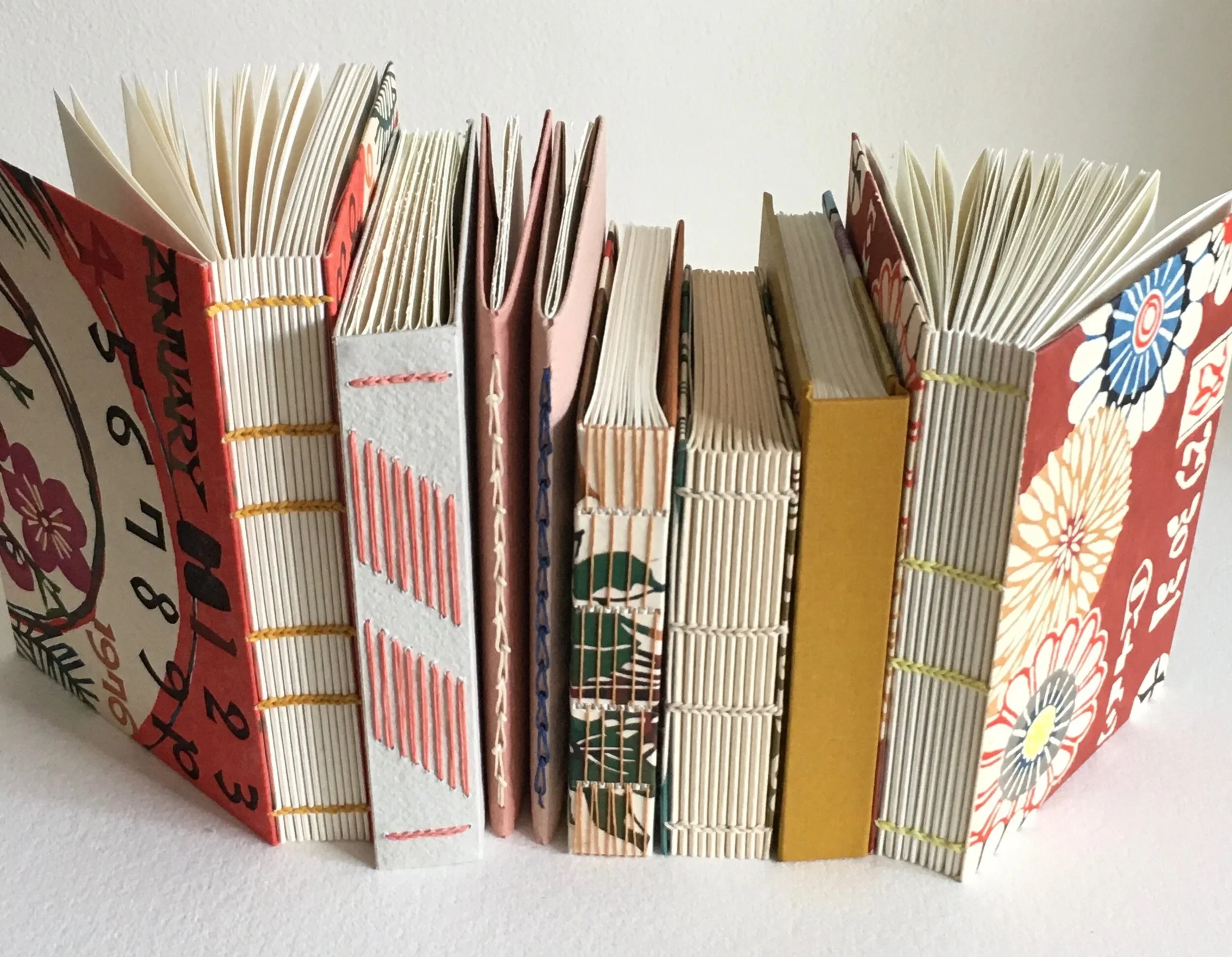 A table with various colorful books showing their different bindings.