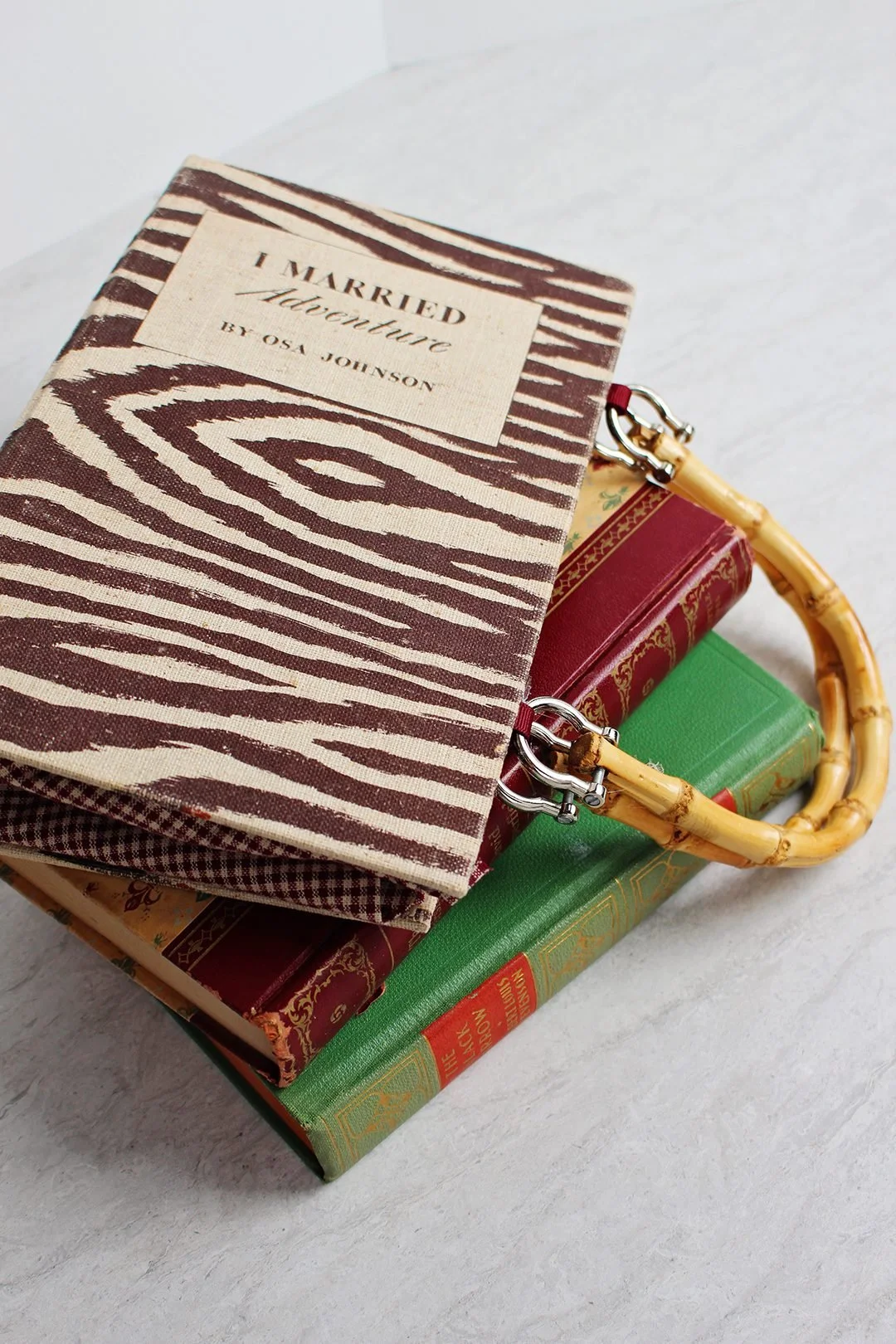 Table with 2 books stacked on top of each other as well as a bag designed as a fake book.