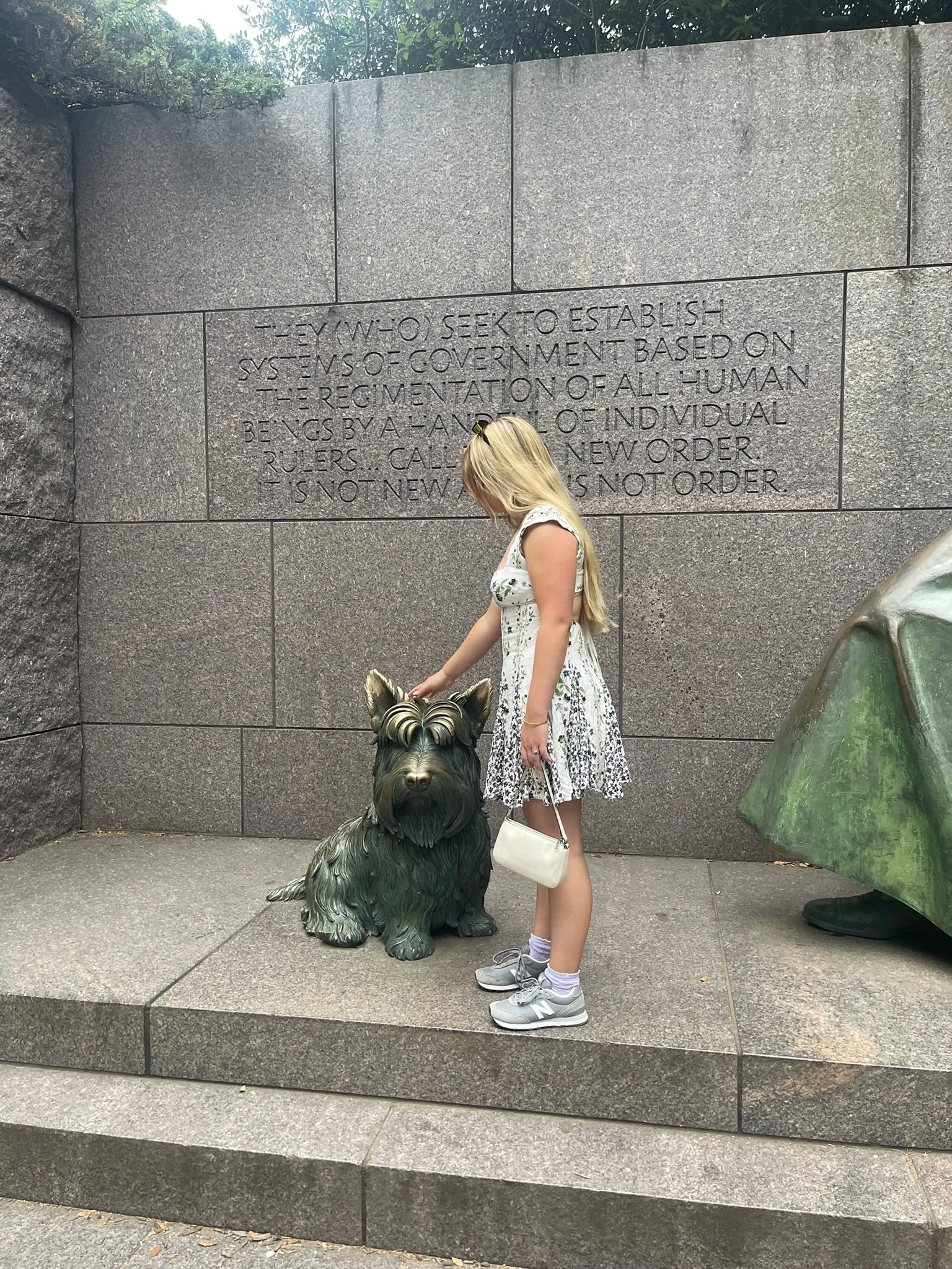 Gabrielle petting a dog statue in DC because every dog deserves pets