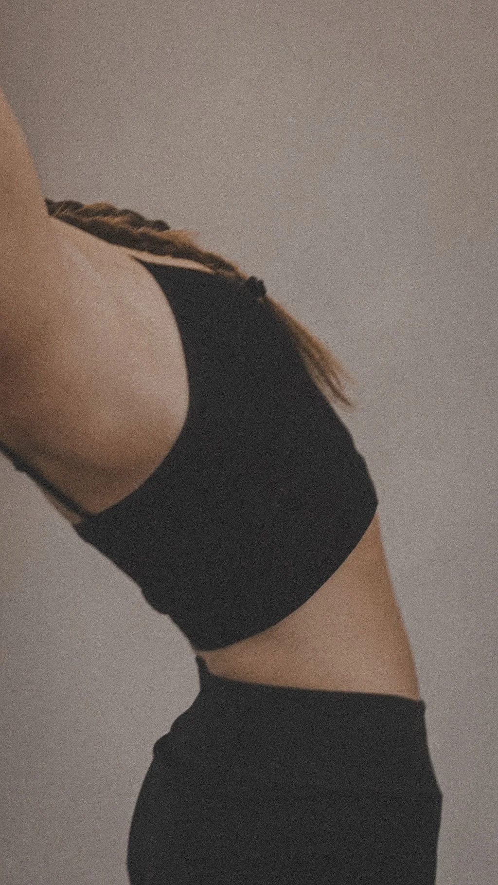 Side view of a Pilates client in Kalbarri wearing black activewear during a reformer Pilates class at Mid West Movement . Small group and 1:1 Pilates sessions available in Kalbarri WA region.