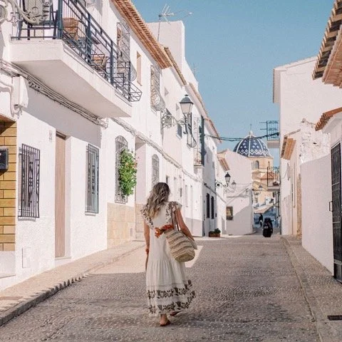 Denisa O. Nica, walking away down a cobble path in Spain