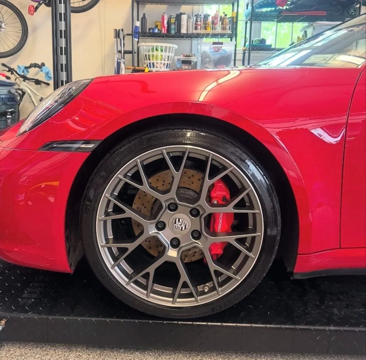 Close-up of a red sports car tire and wheel with Porsche and Brake caliper branding in Arroyo Grande