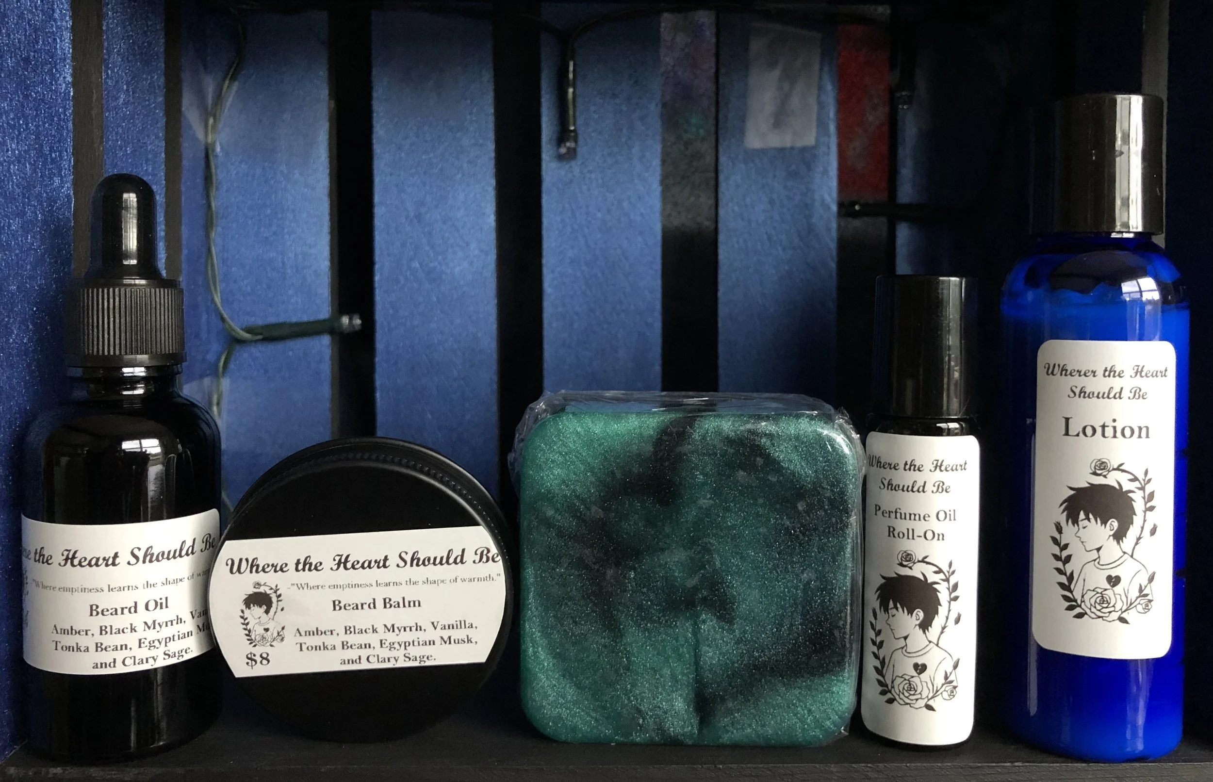 A collection of self-care products including beard oil, beard balm, a green and black sponge, perfume oil roll-on, and lotion bottles, displayed on a shelf with black and blue background.