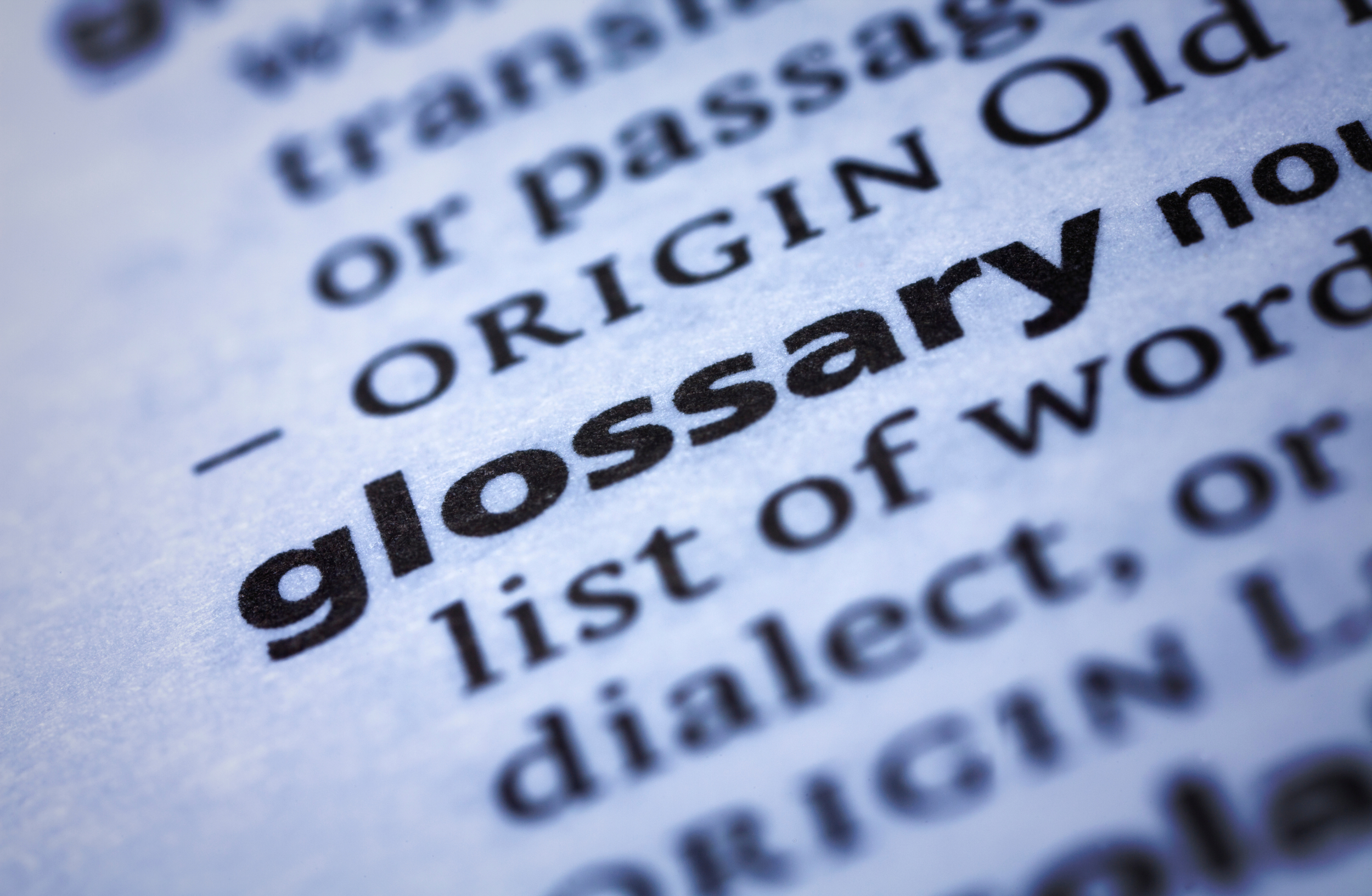 Close-up of printed dictionary page focusing on the word "glossary".