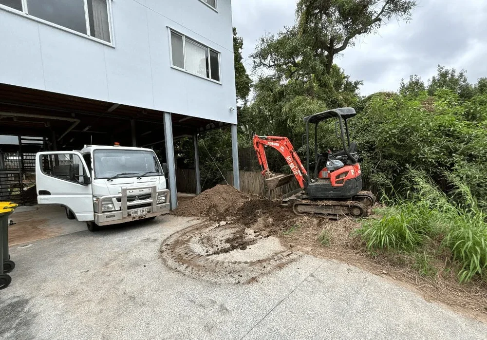 A construction site with a large excavator demolishing a building, rubble and debris scattered around, two construction workers in safety vests and helmets monitoring the work.