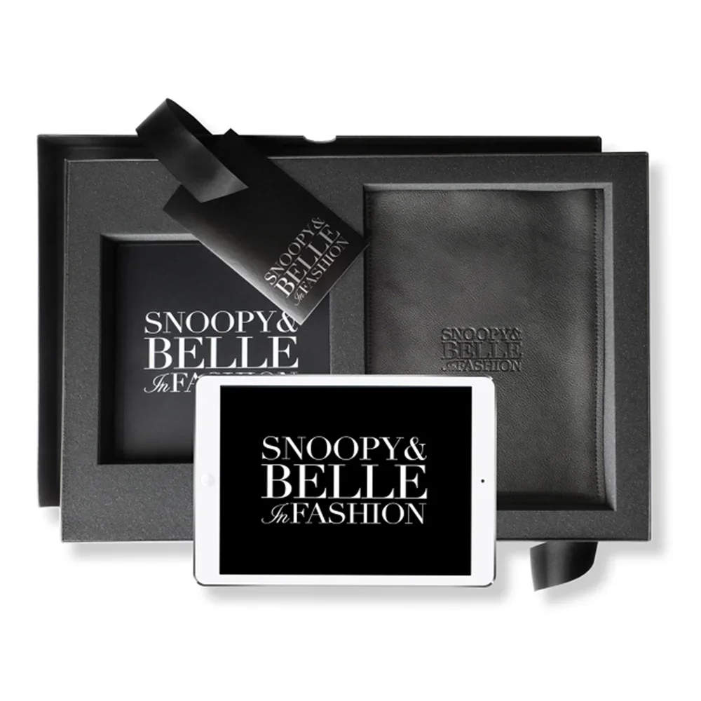 A black and white gift set featuring a tablet with stylized text 'SNOOPY & BELLE In FASHION,' a framed item with the same text, a leather envelope, and black ribbon.