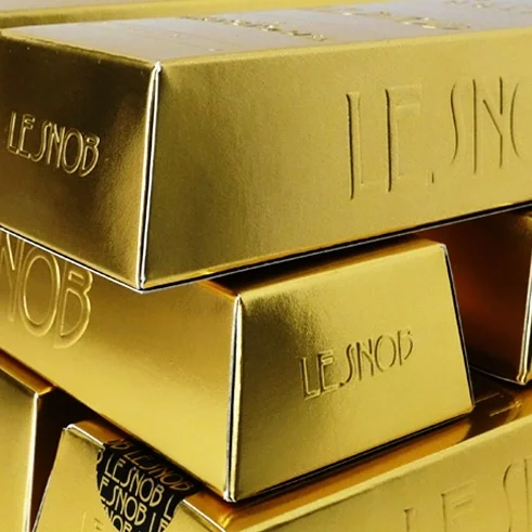 Stacked gold bars with engraved text.
