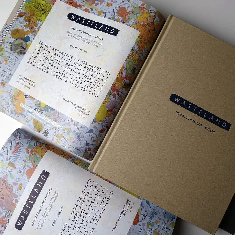Open book and pamphlet promoting an art exhibition called 'Wasteland' at Galerie Thaddaeus Ropac, featuring new art from Los Angeles with artwork list and colorful background map.