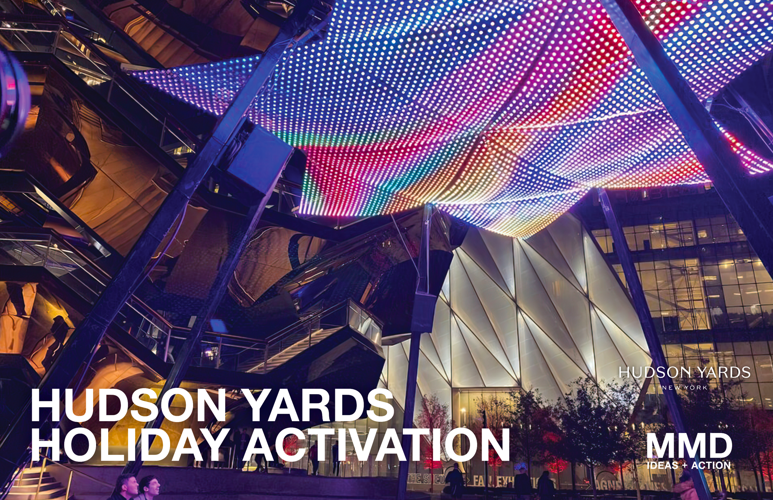 Colorful LED canopy lighting above modern architectural building at night, with trees and people in front, promoting Hudson Yards holiday activation by MMD Ideas & Action.