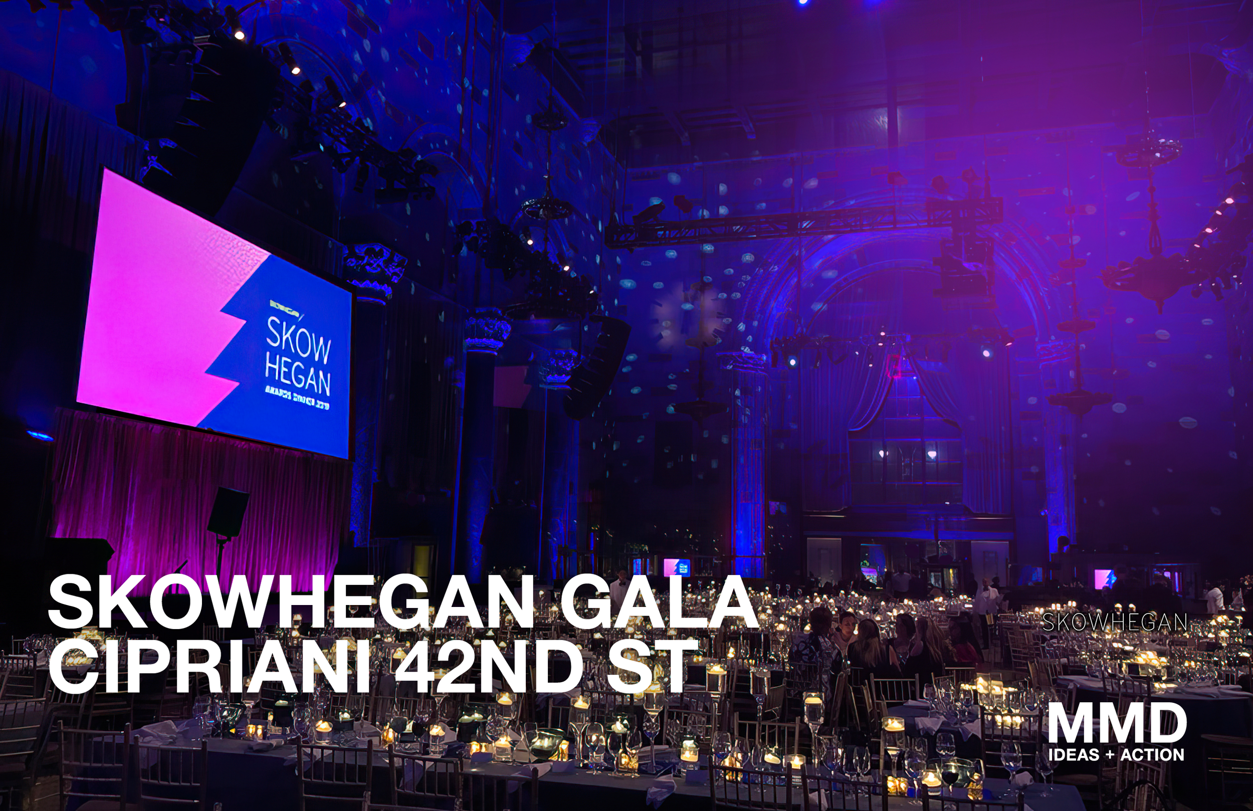 Inside a large hall decorated for the Skow Hegan Gala at Cipriani 42nd Street, with tables set for a formal event, purple and blue lighting, a large screen displaying 'Skow Hegan', and ornate interior architecture.
