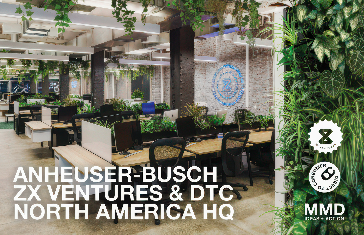 Open-plan office space with desks, chairs, and large green plant decor, and a prominent logo on a brick wall.