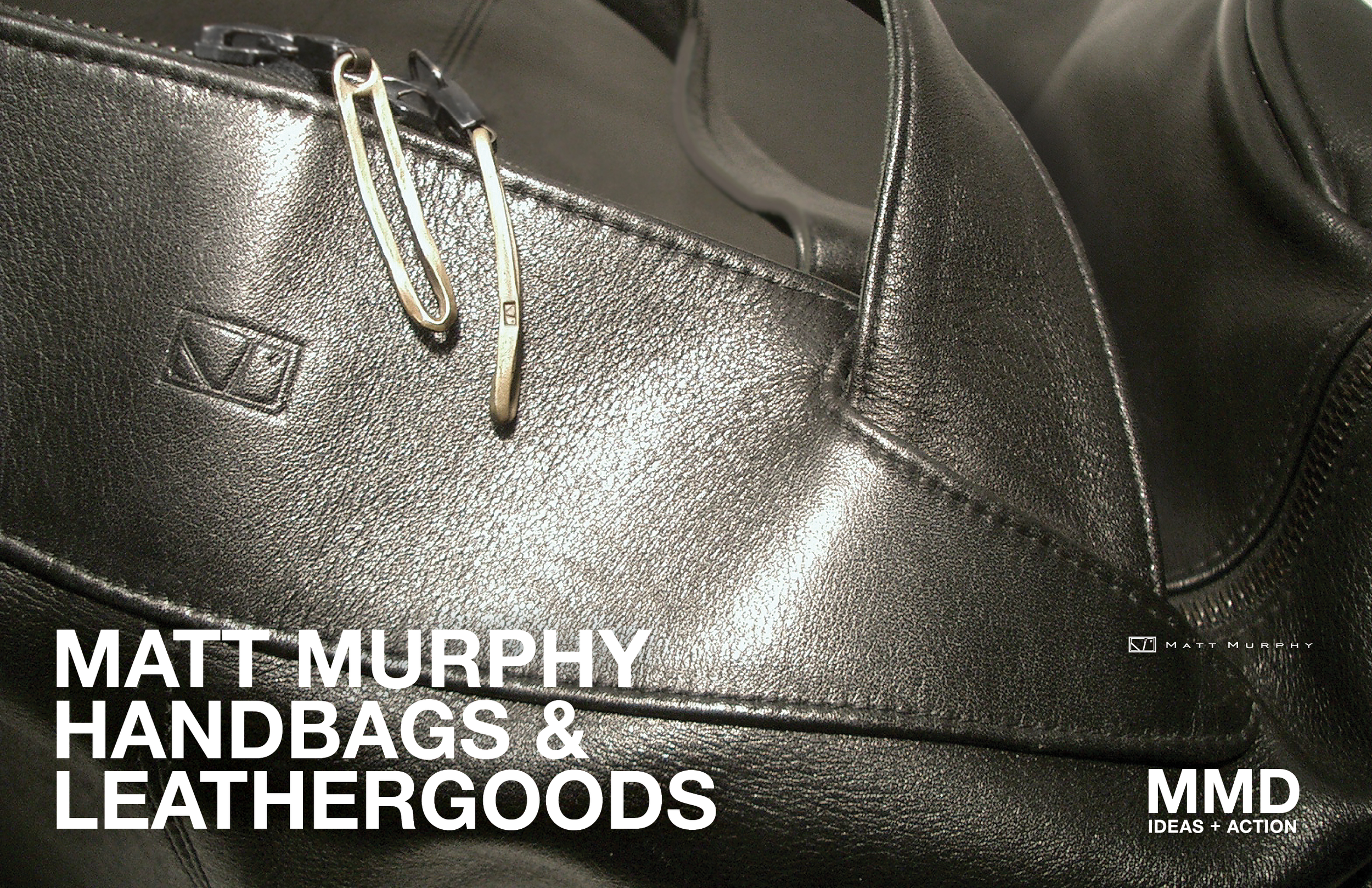 Close-up of black leather handbags, one with a silver zipper and a paperclip attached, with a matte texture and visible stitching, partially open, set against a black background.