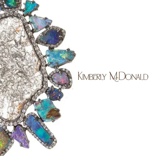 A close-up image of a piece of jewelry with colorful opal stones encased in a silver setting.