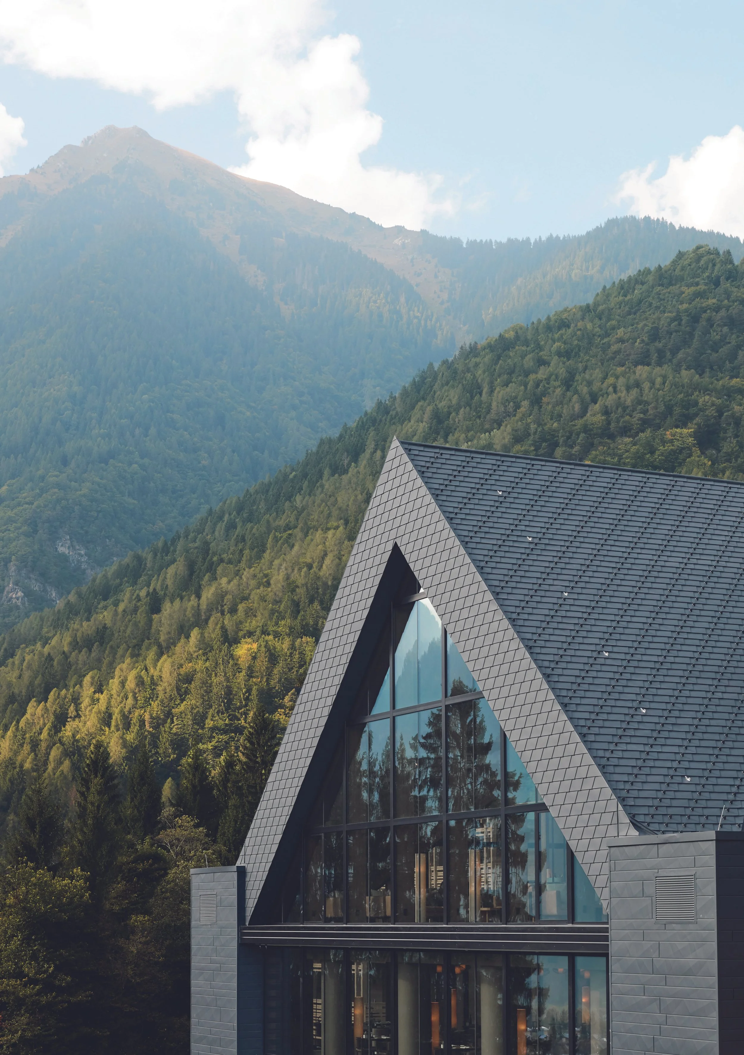 Lefay Resort & Spa Dolomiti exterior with forested alpine landscape