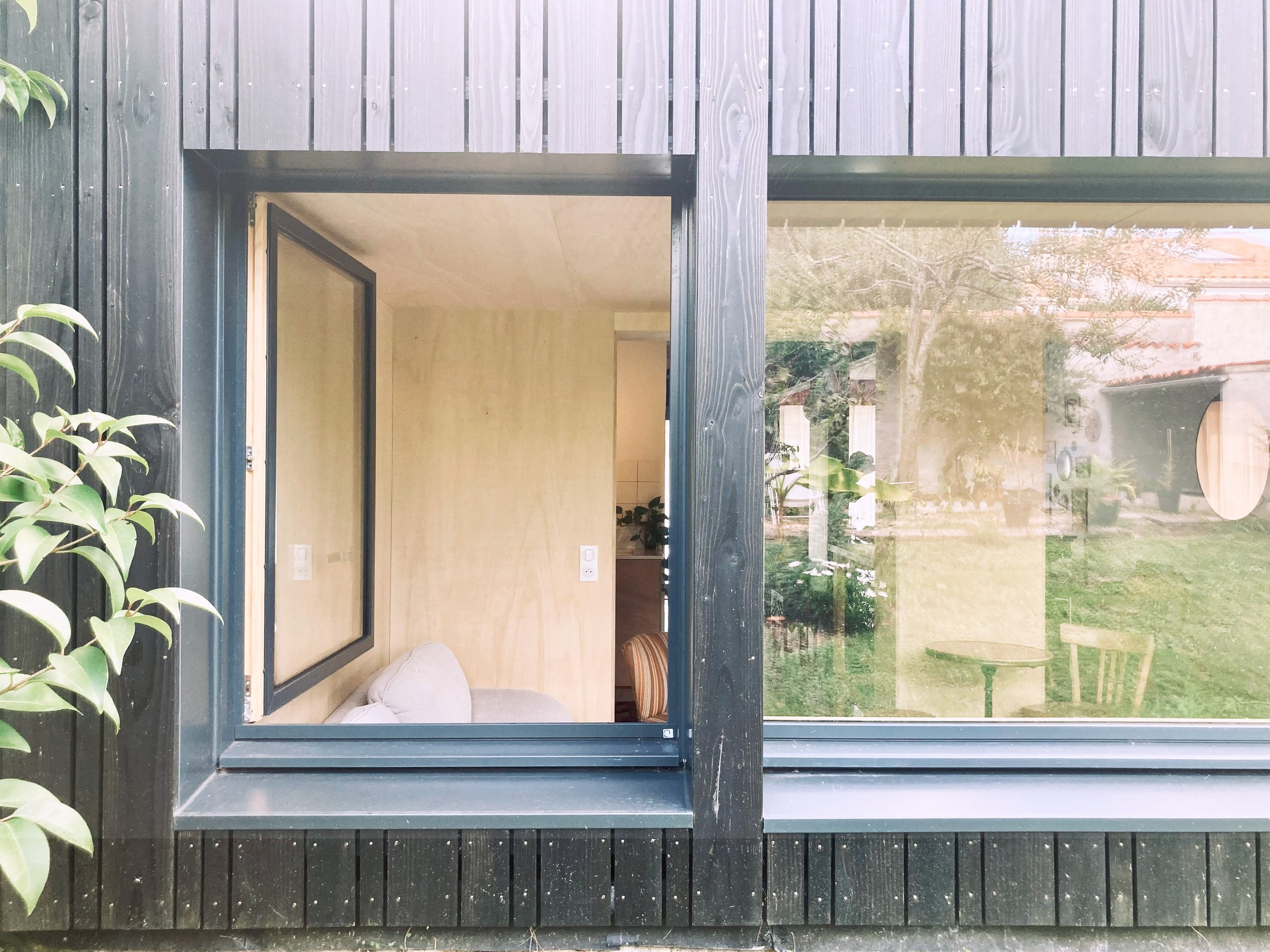 Maison contemporaine habillée en bardage bois brûlé, combinant esthétique naturelle et modernité. Les fenêtres à double face (intérieur bois / extérieur aluminium).