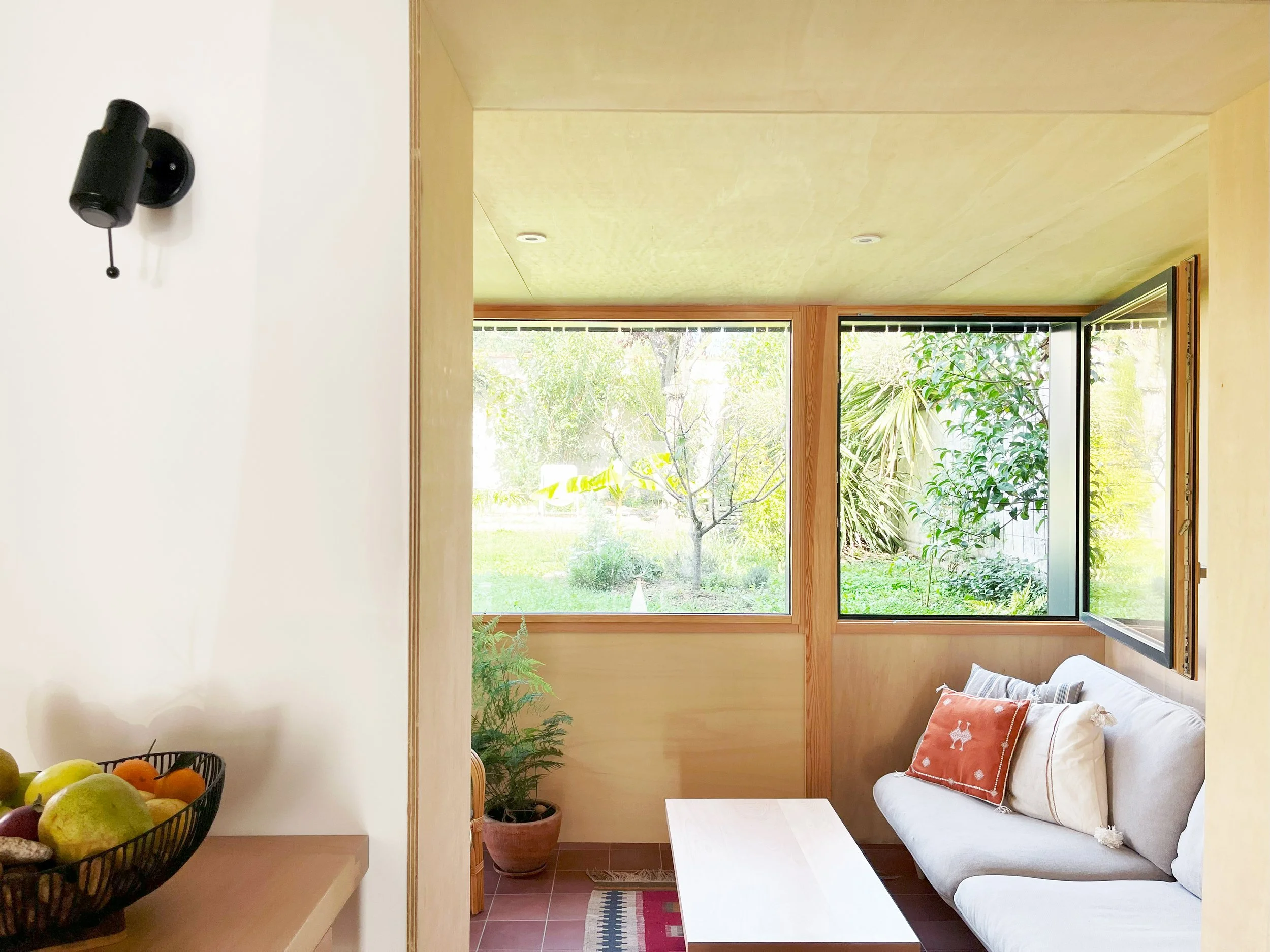 Intérieur extension en bois contreplaqué, fenêtres bois et aluminium, sol color tracotta moderne et lumineux