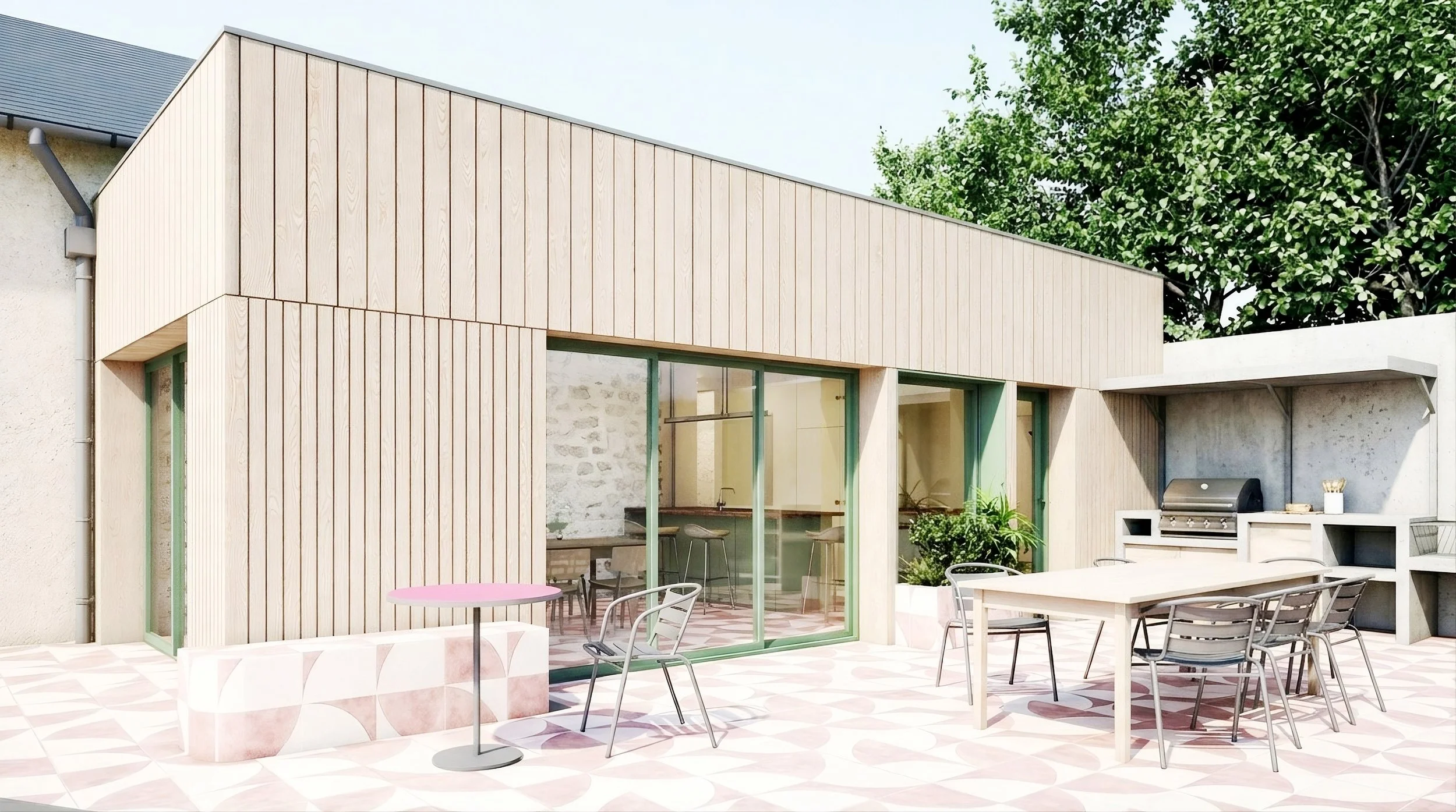 Extension de maison en ossature bois avec grande baie vitrée ouvrant sur une terrasse extérieure aménagée et une cuisine d'été conviviale, intégrée dans un jardin paysager.