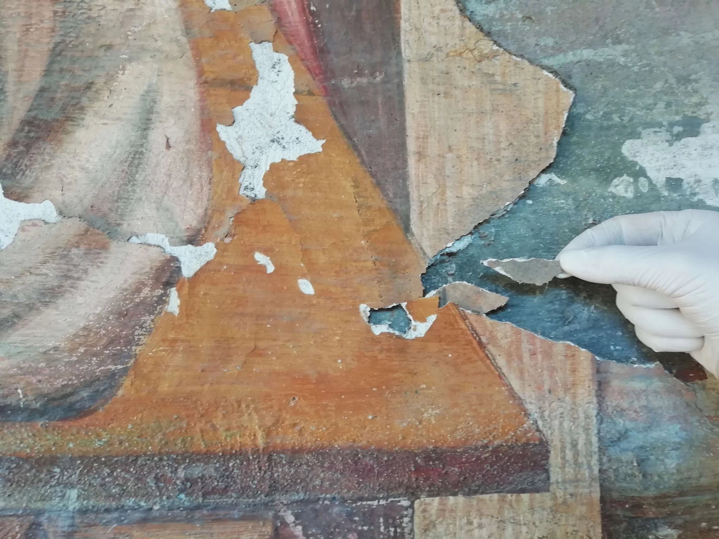 Dettaglio delle mani di Clementina mentre lavora a un piano diagnostico per la conservazione.