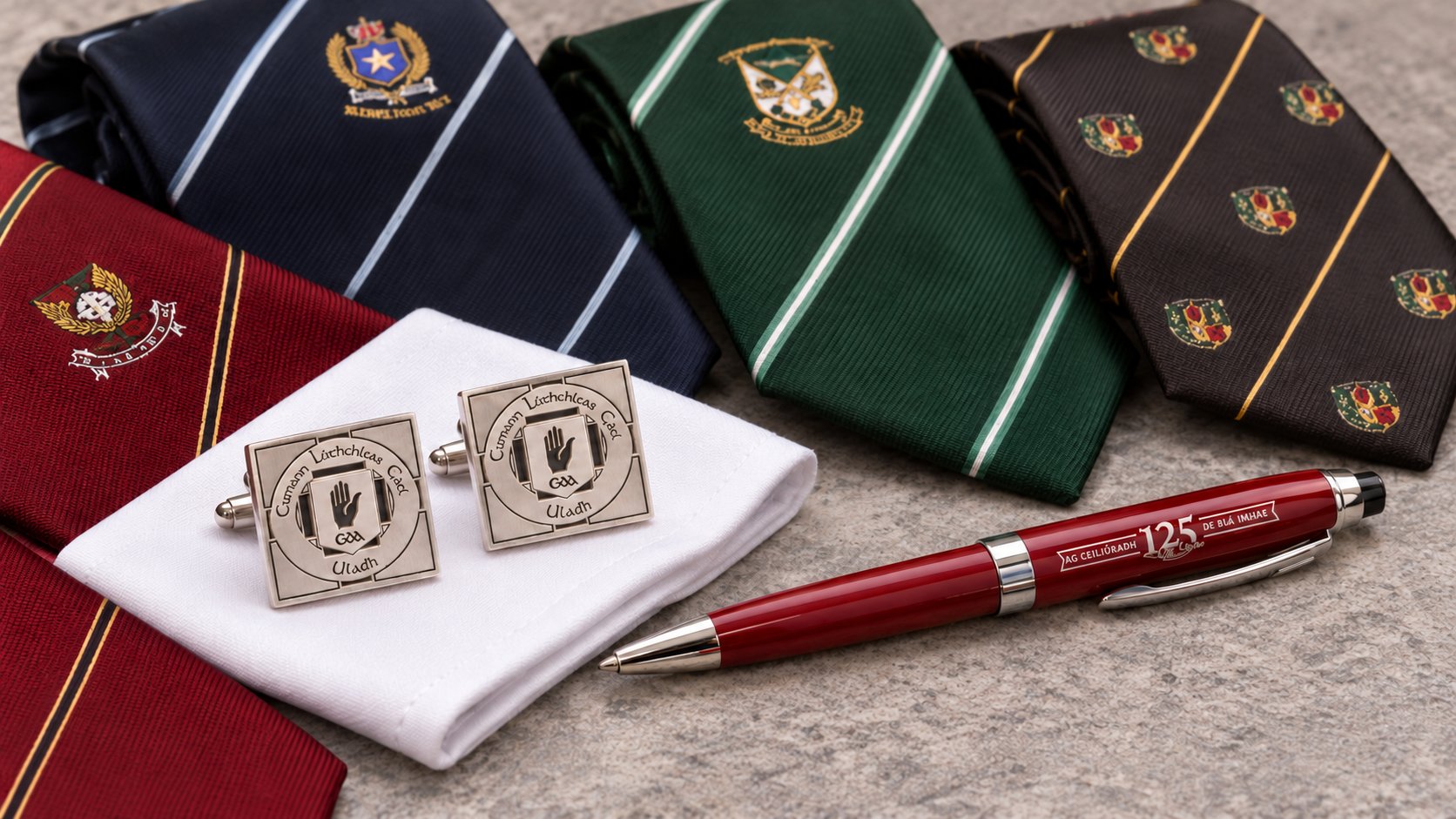 A close-up of a cufflink on a white shirt sleeve. The cufflink has an Irish design with the words 'Cumann Lúthchleas Gael' and a black hand symbol in the center.