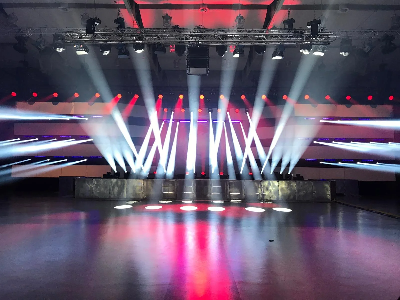 Empty stage with colorful bright lights and laser beams, set up for a concert or event.