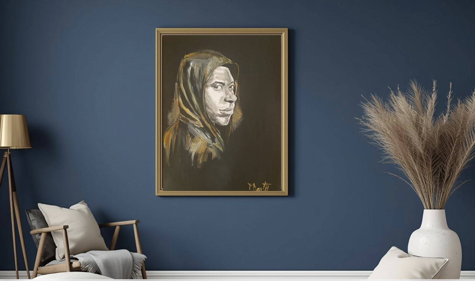 Une peinture d'un portrait en noir et blanc d'une femme portant une capuche, encadrée en or, suspendue sur un mur bleu dans un intérieur élégant. À gauche, une lampe en or et un fauteuil avec des coussins, à droite, un grand vase blanc avec des branches de paille.