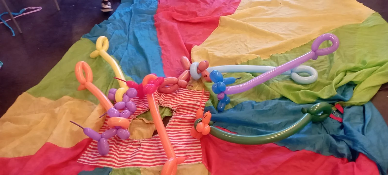 Decorazioni con palloncini colorati su una superficie ricoperta da tessuti colorati.