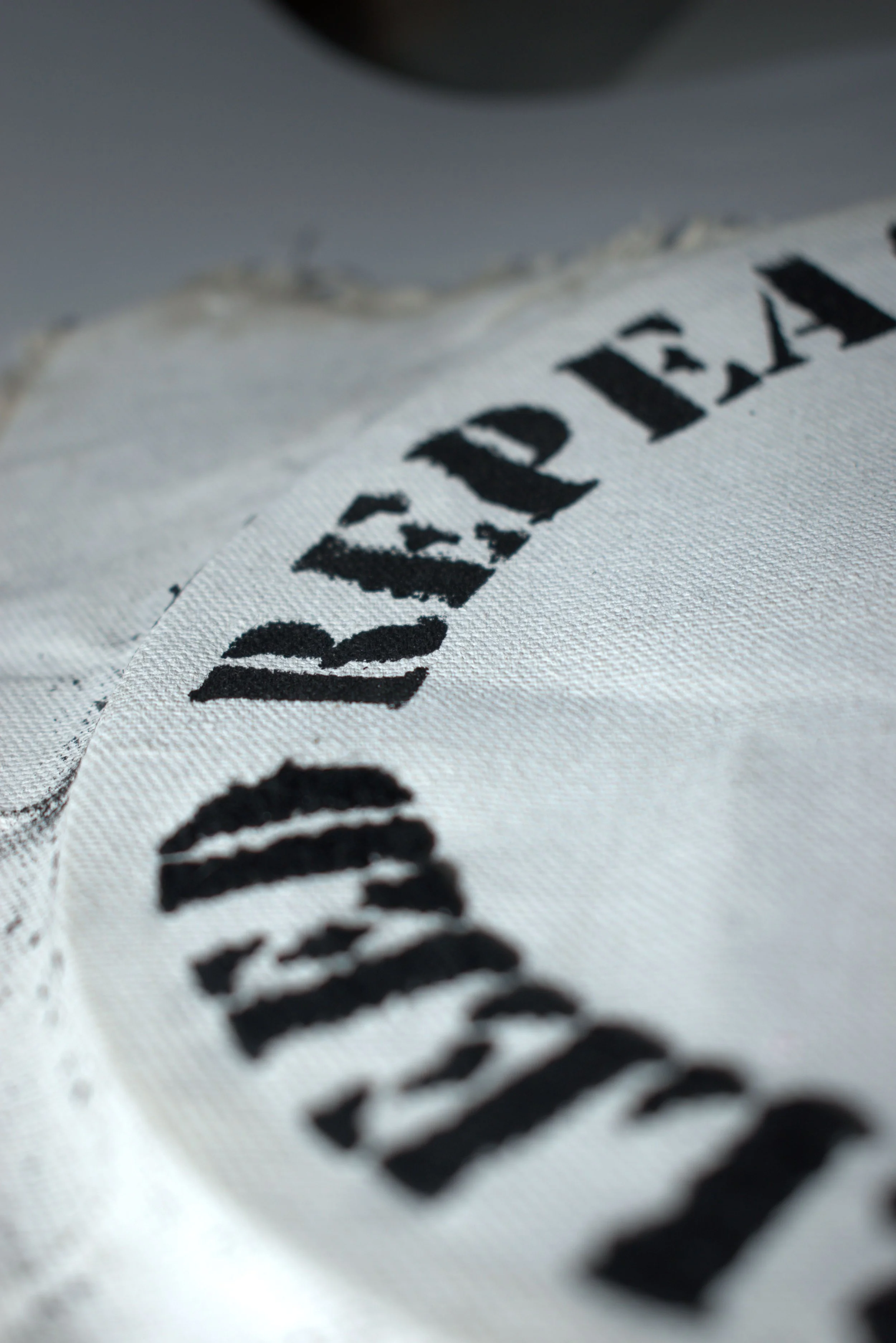 Close-up of a white fabric tag with black printed text, partially visible.