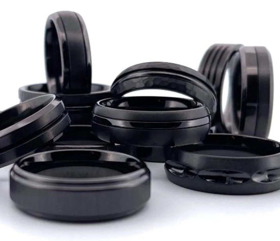 Multiple black hockey pucks on a white surface.