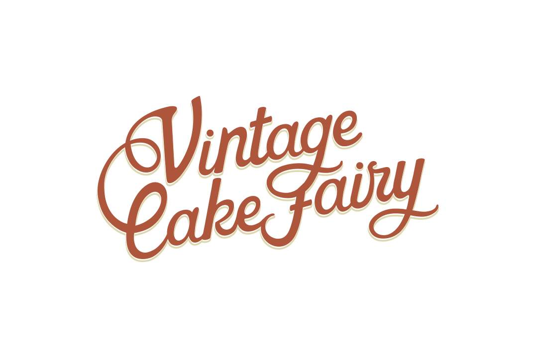 Vintage Cake Fairy logo with cursive lettering in brown on a white background.