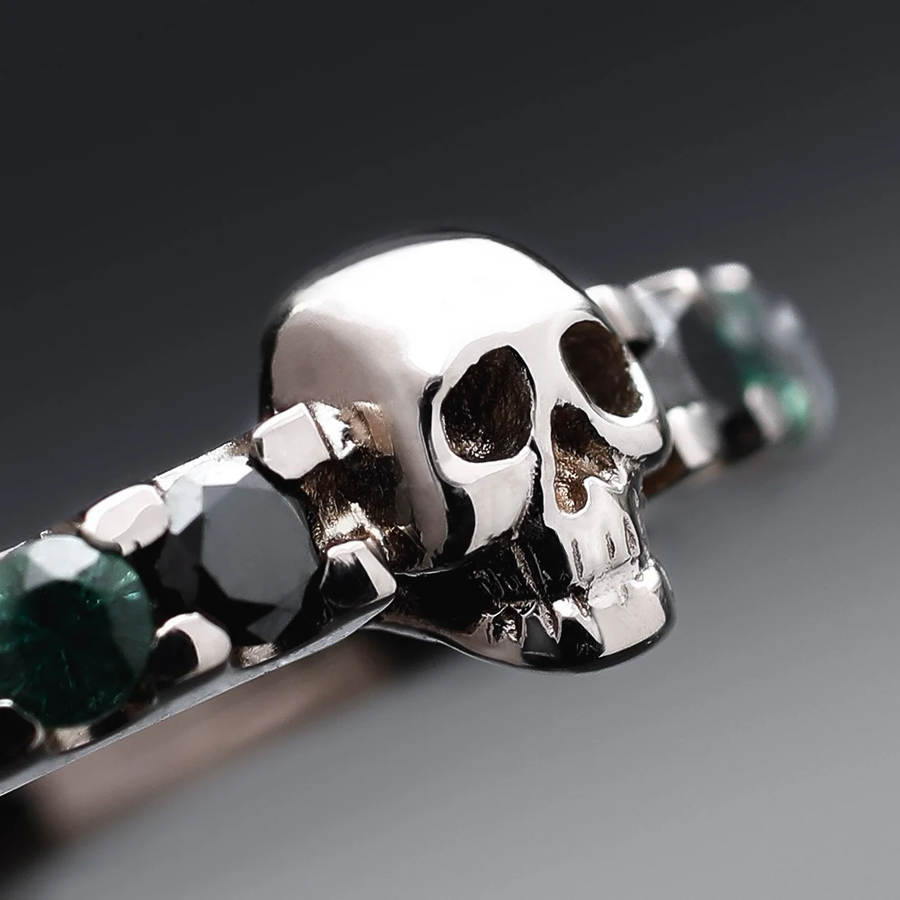 A silver bracelet featuring a skull design with dark eye sockets.