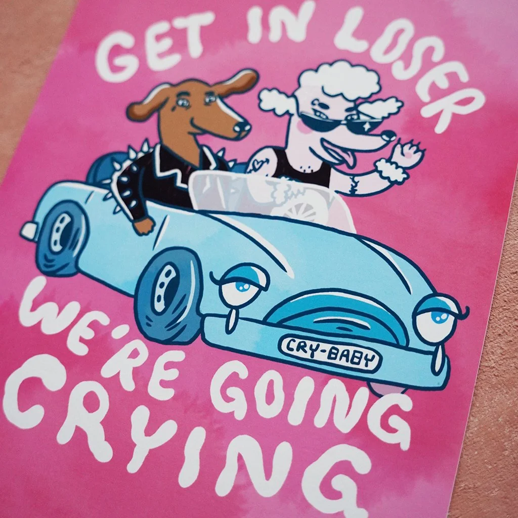 Pinkki juliste, jossa auto ja kaksi koiraa. Auton rekisterikilvessä lukee "Cry-Baby". Tekstissä lukee "GET IN LOSER WE'RE GOING CRYING".