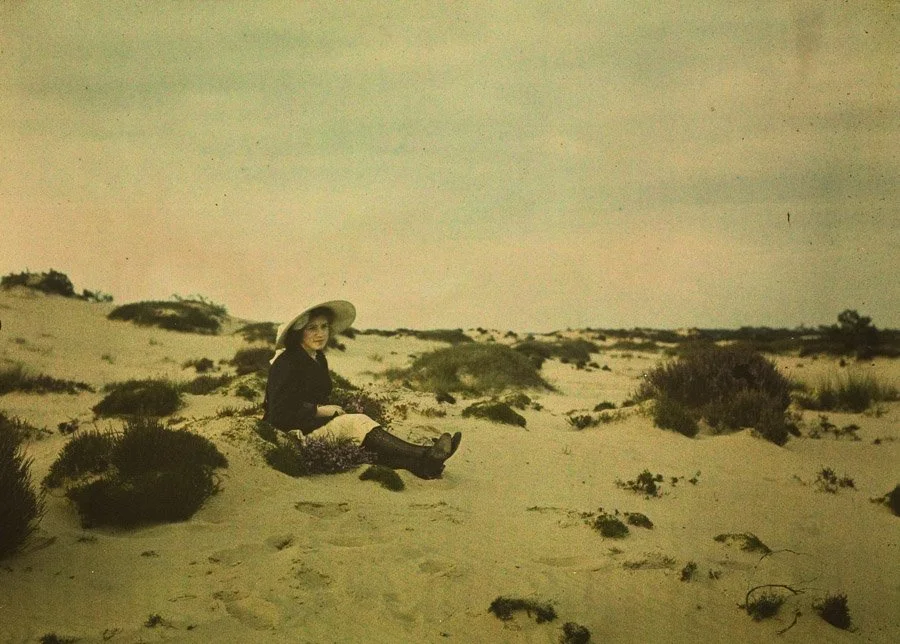 vintage photograph of a woman sitting in sand dunes