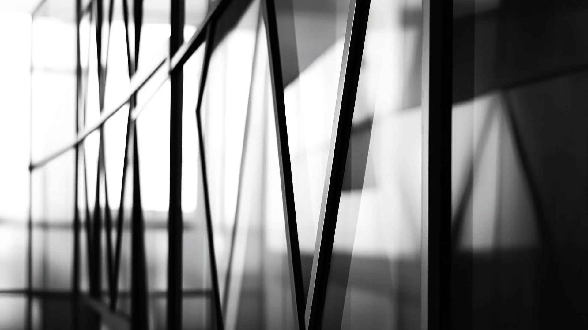 Close-up of a modern architectural wall with black metal grid pattern and reflective surfaces, lit from behind creating bright highlights and shadows.