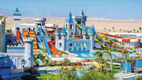 Colorful water park in Egypt with castles, water slides, and pools in a desert landscape.