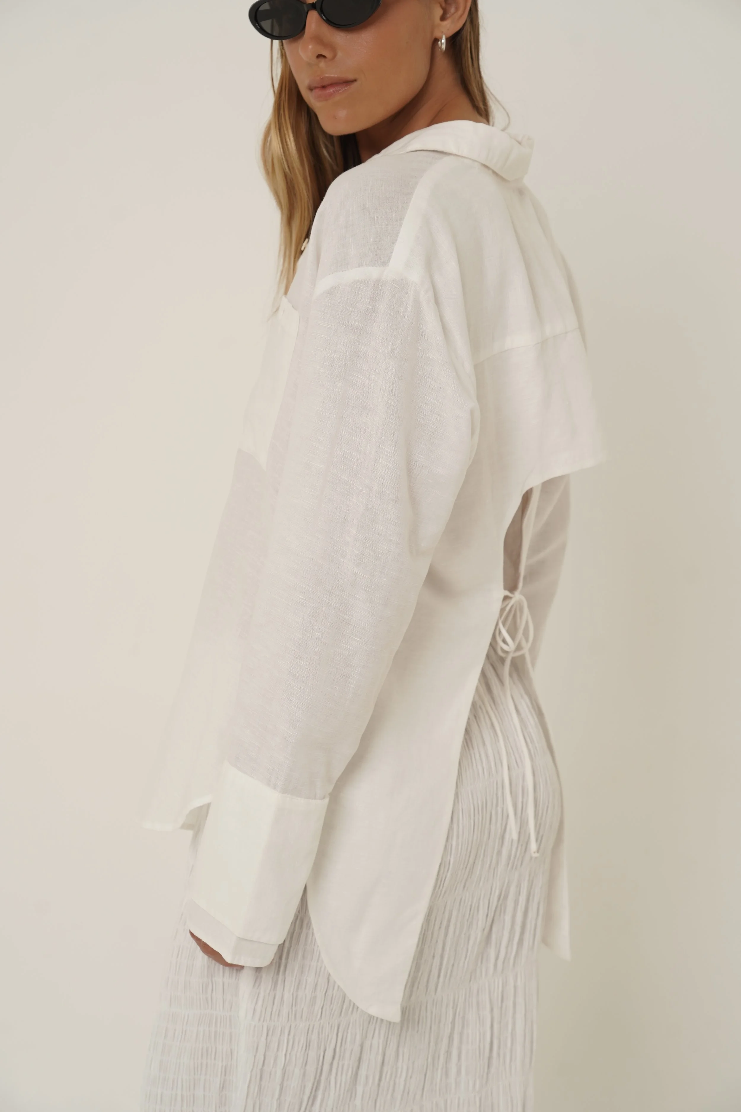 Woman wearing linen Reformation Shirt looking sideways
