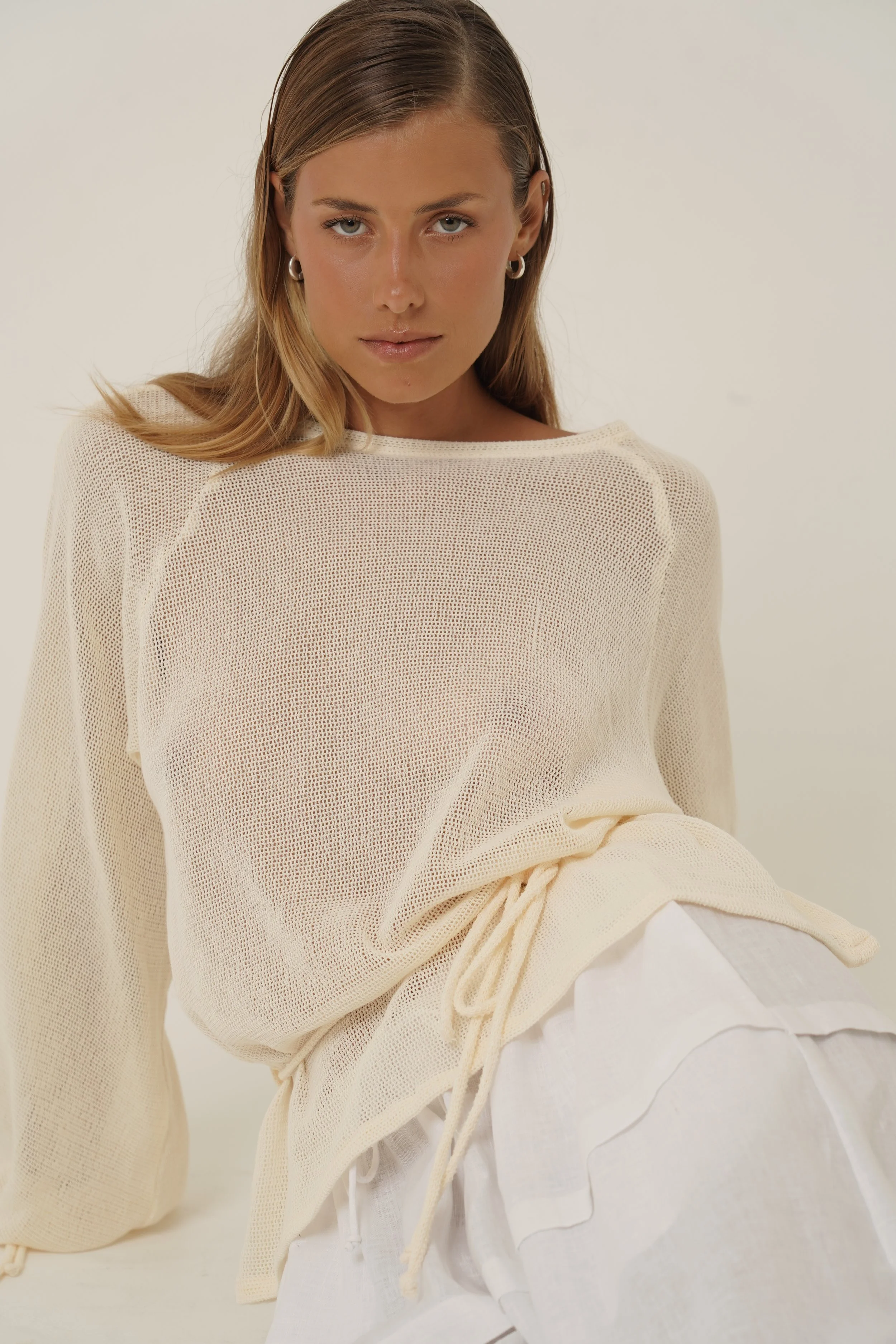 Woman sitting on the floor with Kaos Shirt and Kaos Pants