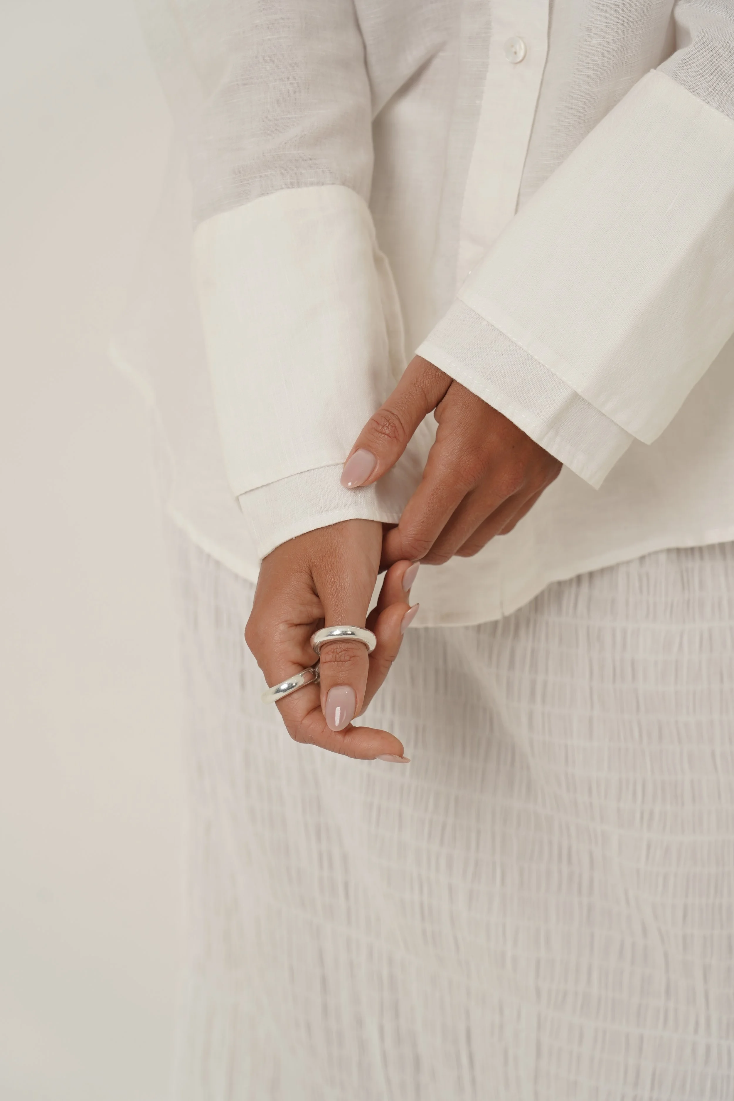 Detail of cuffs and hands white Reformation Shirt in pure linen
