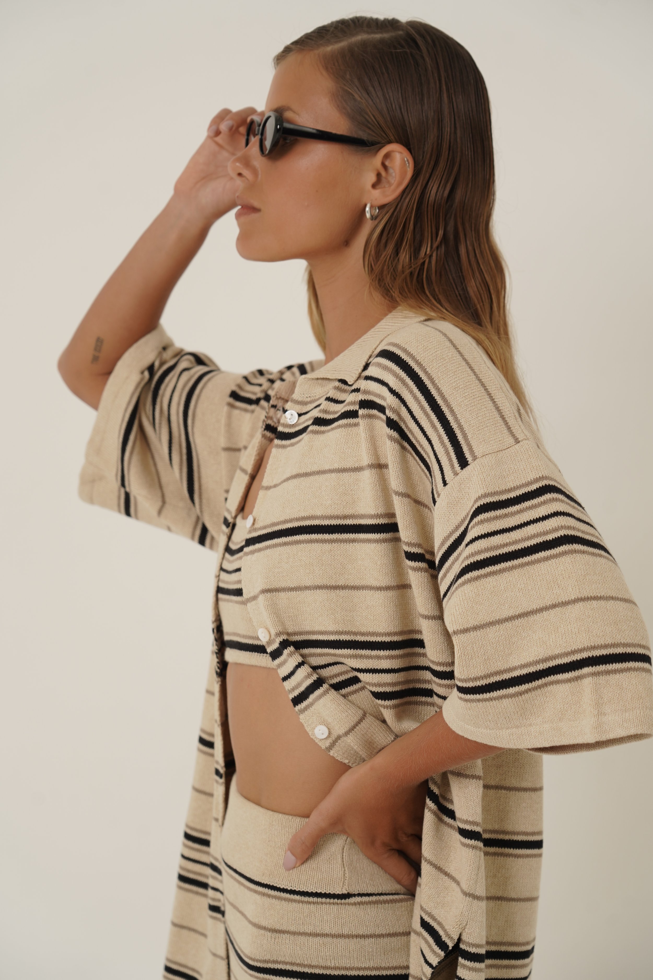 Woman wearing Dune Shirt and Top with striped pattern in cotton knit holding sunglasses