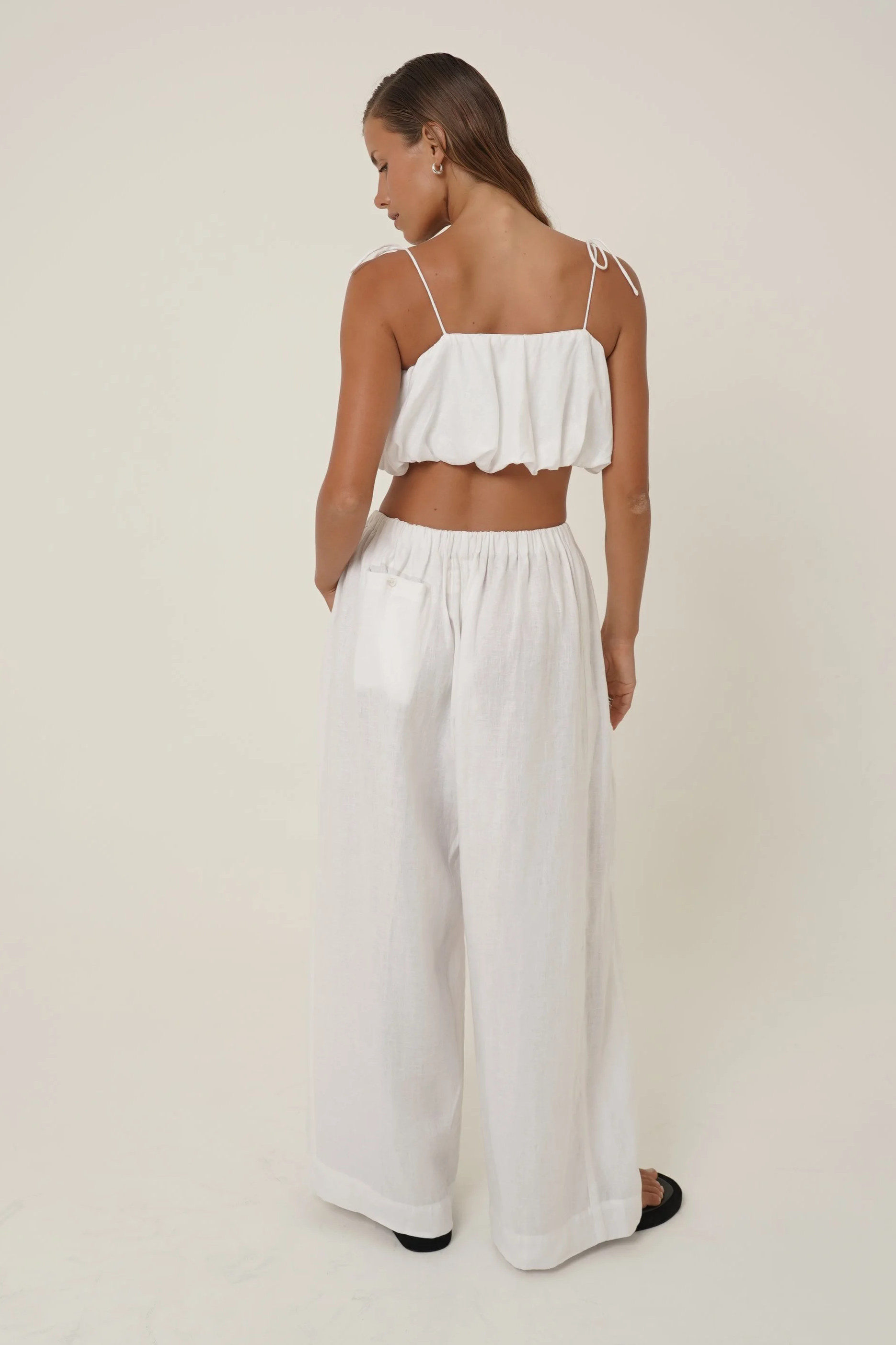 Woman wearing  white linen Crescendo Pants and Top - back